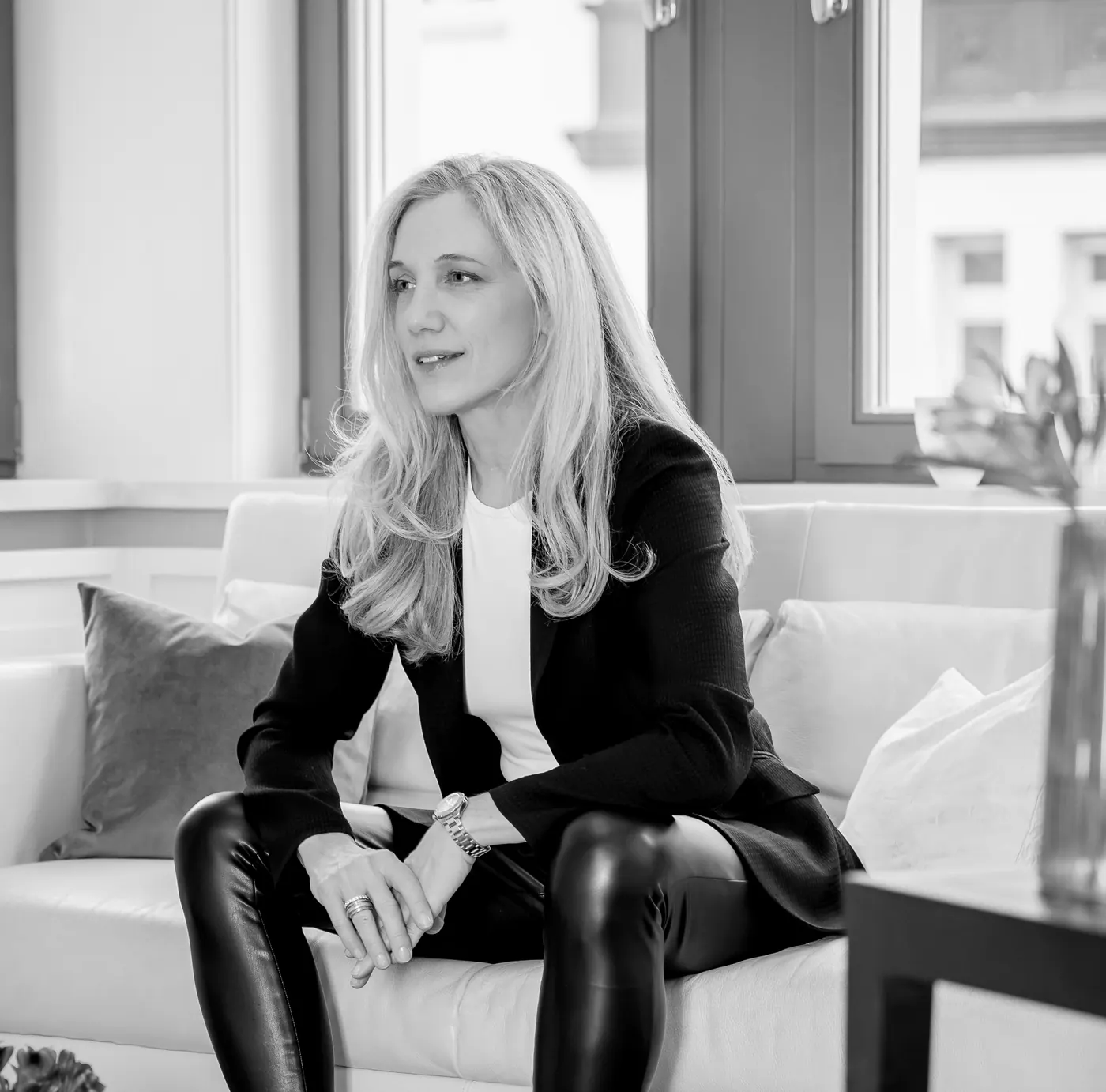Isabel Schürmann sitzt auf einem Sofa und blickt zur Seite