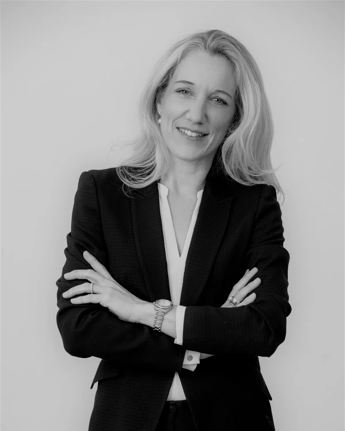 Isabel Schürmann im dunklen Blazer mit verschränkten Armen, lächelnd
